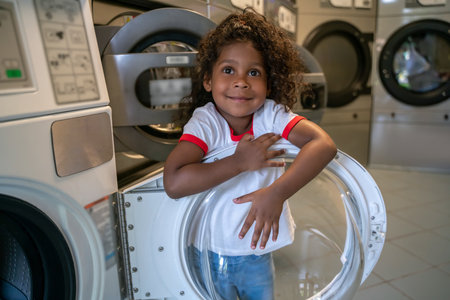 Pleased child playing at a public launderetteの写真素材
