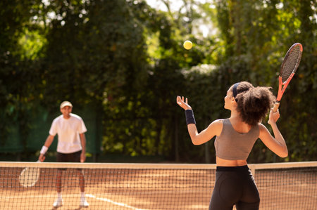 Two young people playing tennis and looking excitedの写真素材