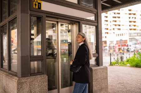 Long-haired woman in a black coat entering subwayの写真素材
