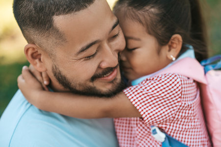 Young man and his daughter in the park after a day togetherの写真素材