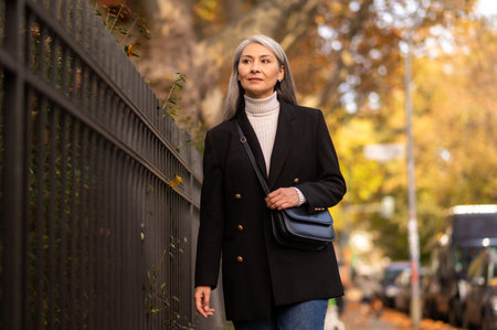 Pretty mature woman walking in the autumn park