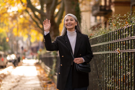 Pretty mature woman walking in the autumn parkの写真素材