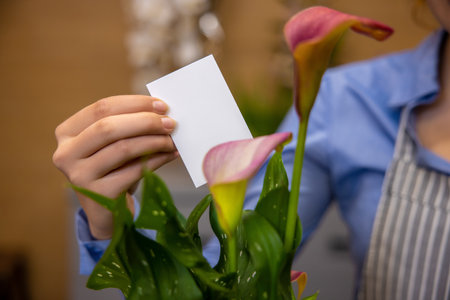 Close up of female hand putting a card in a bouquet