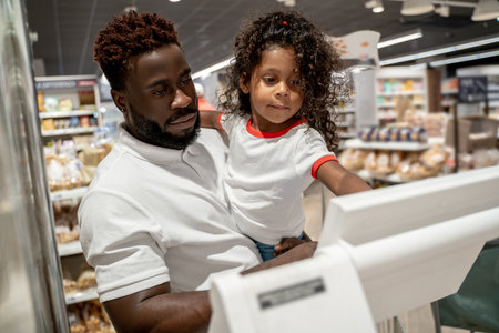 Man and his daughter in a supermarket doing shoppingの写真素材