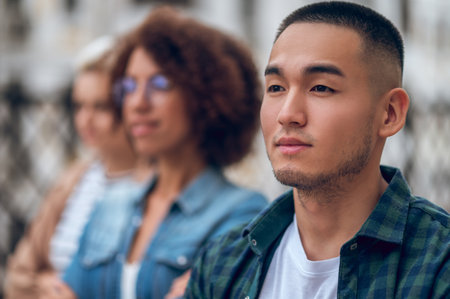 Cute pensive young man in the company of womenの写真素材