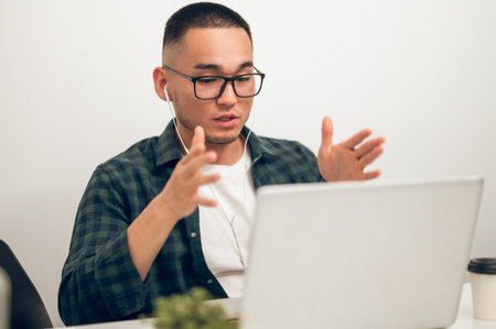 Corporate manager seated at the laptop communicating via video callの写真素材