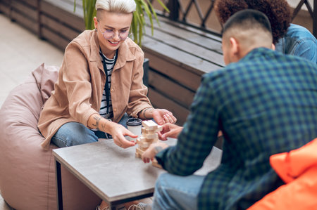 Company of three playing wooden blocks on the veranda