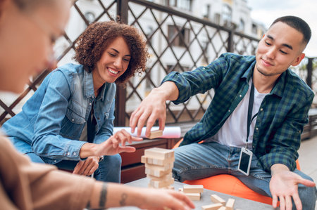 Three office employees involved in playing a board gameの写真素材