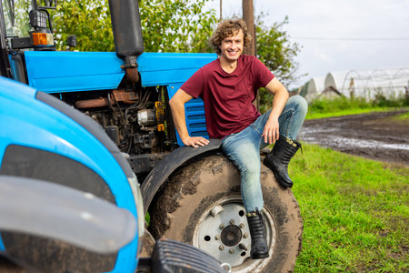 Joyful worker posing for the camera on the farm vehicleの写真素材