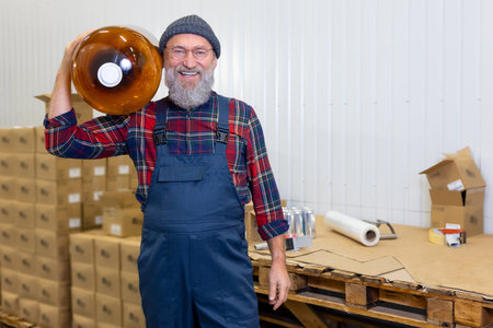 Smiling pleased loader standing in the factory warehouse