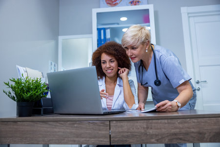 Two female doctors discussing something at the laptop in the clinicの写真素材