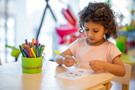 Cute little girl drawing in a play room