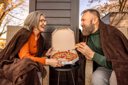 Couple having pizza for lunch and looking xontentedの写真素材