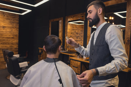 Male barber combing the clients hairの写真素材