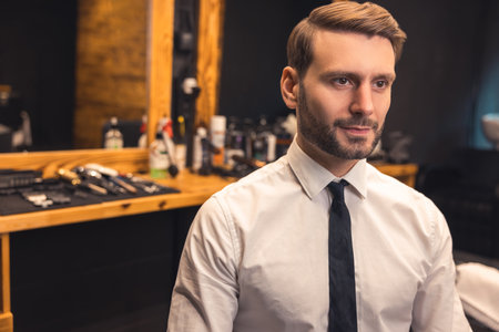 Good-looking confident businessman in a barbershopの写真素材