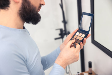 Adult man using a thin brush for blending eye shadowsの写真素材