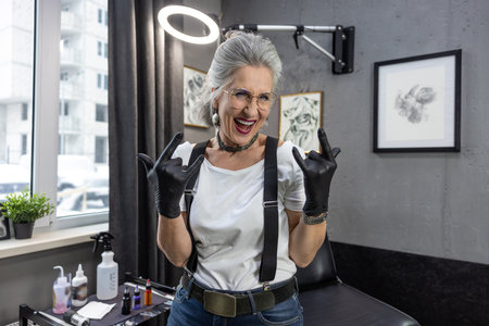 Gray-haired tatoo master looking excited and enjoyedの写真素材