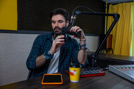 Dark-haired young man with a microphone in handの写真素材