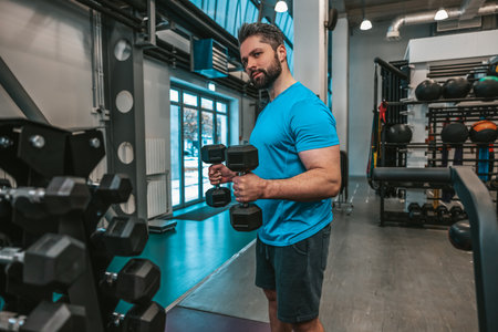 Man working with dumbbells in a sports clubの写真素材