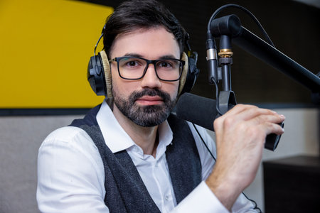 Dark-haired young man in headphones looking seriousの写真素材