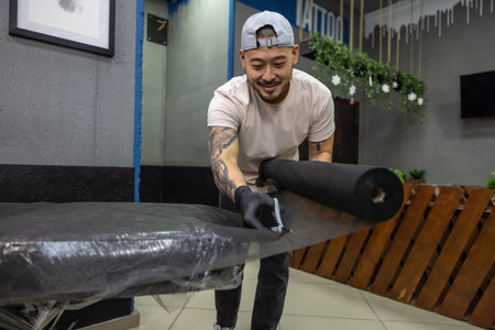 Asian tattoo master preparing couch for tattoo session