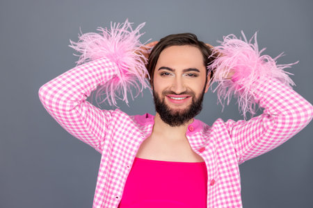 Cheerful smiling transgender person wears pink clothing posing having fun on party laughing happily