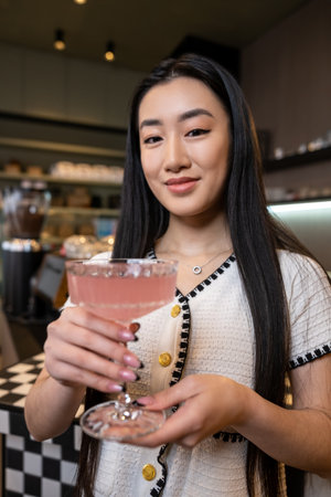 Pleased female with a beverage in her handsの写真素材