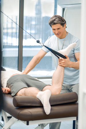 Male patient having a leg hyperextension in a rehabilitation center