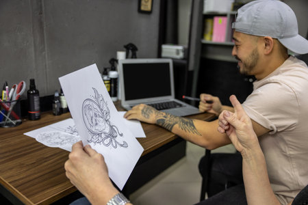 Tattoo master and a customer choosing a tattoo sketchの写真素材