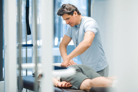 Male patient having a session of rehabilitation back massageの写真素材