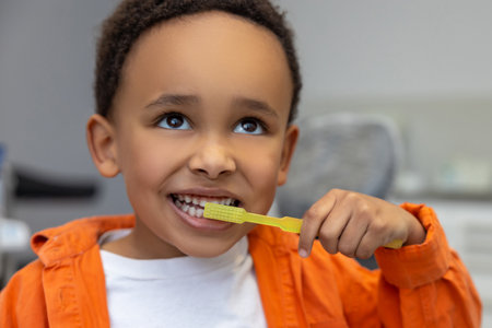 African-american boy looking involved while brushing his teeth