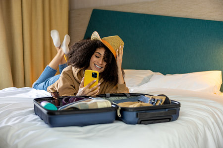 Cute young woman making slefie on the bed in the hotelの写真素材
