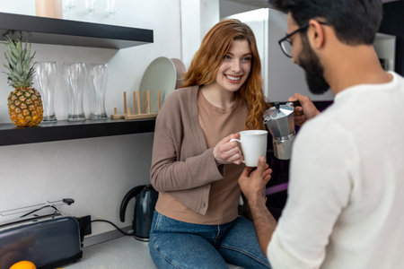 Couple enjoying drinking coffeee together in kitchen at home, expressing love.の写真素材