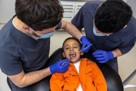 Dentist and his assistant treating boys teethの写真素材