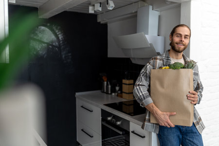 Man holding paper grocery shopping bag full of fresh healthy food vegetables in his hand.の写真素材