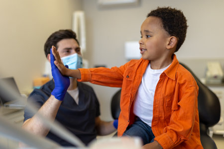 Doctor and little patient doing high five and looking contentedの写真素材