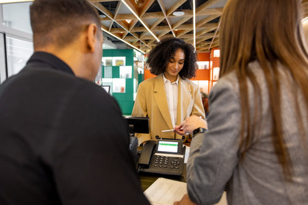 Receptionist helping a guest to check inの写真素材