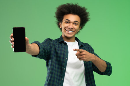 Excited you ng dark-skinned man with a smartphoneの写真素材