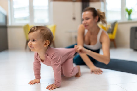 Healthy development. Athletic mother and baby girl exercising together.の写真素材