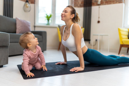 Healthy development. Athletic mother and baby girl exercising together.の写真素材
