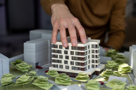 Man architect working in office on creation of new residential complex designing layout of buildingsの写真素材