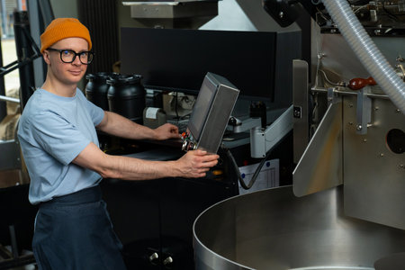 Man working in coffee roasting factory, operating process of creating coffee.の写真素材