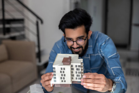 Young engineer looking busy and involved while preparing a house mock up
