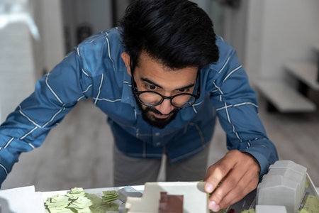 Young engineer looking busy and involved while preparing a house mock up