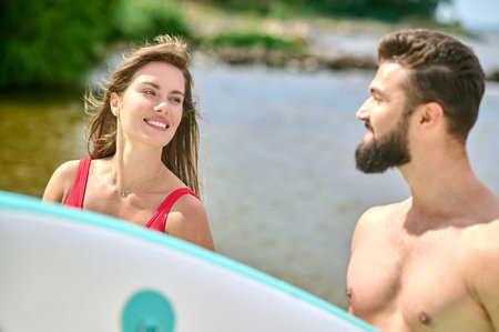 Romantic man and woman young surfers on beach, enjoying vacation near sea and extreme sport.