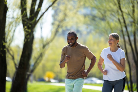 Mature couple jogging in the park in the morningの写真素材