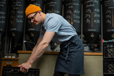 Caucasian man coffee shop worker gets new batch of coffee packages in boxes on roasting factory.の写真素材