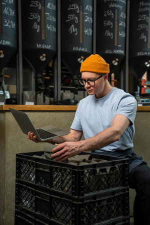 Coffeemaker using laptop in coffeshop accepts new cooffee beans.の写真素材