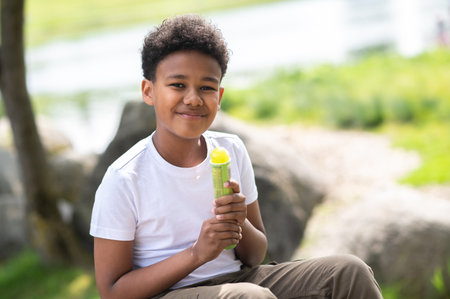 Little boy eating ice cream in park on hot summer day, enjoying sweet dessert during summer holidays.の写真素材