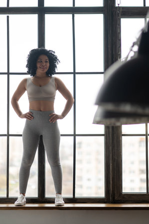 Sporty young woman in grey sportwear